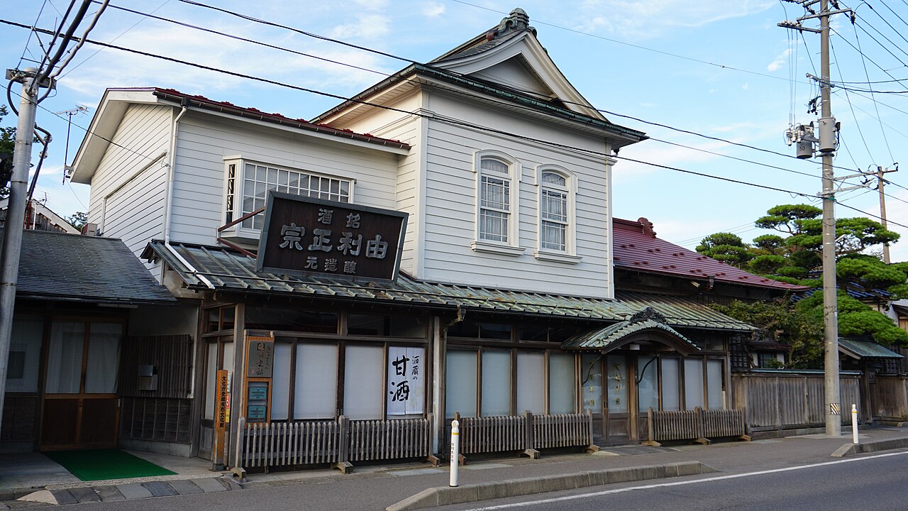 秋田県由利本荘市石脇の齋彌酒造店の店舗。2階に洋風の窓を持つ白い下見板張りの建物に「由利正宗 醸造元」の看板が掛かり、1階は格子戸と障子の町屋の店構え