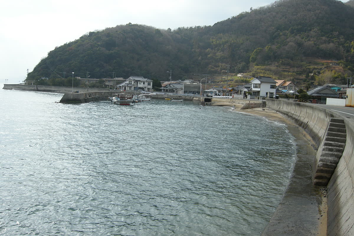 山のふもとに家が並ぶ仁方の海岸と、穏やかな瀬戸内海の入り江