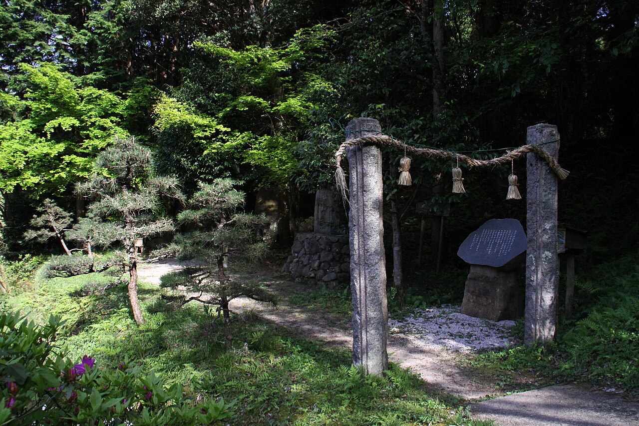 木々に囲まれた小道に、しめ縄を渡した2本の石柱と石碑が立つ黄泉比良坂の伝説地