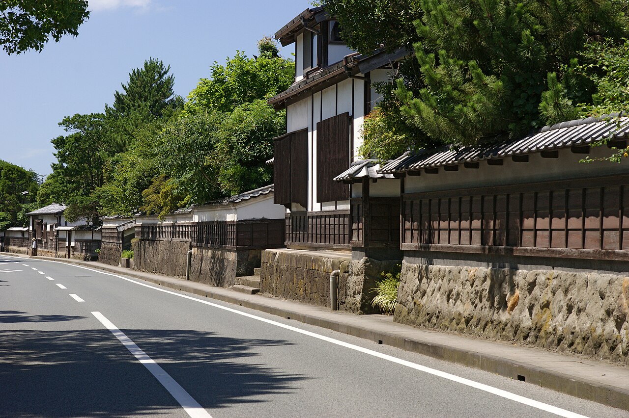 松の木の下に、白壁と板塀、石垣の武家屋敷が道沿いに続く松江の塩見縄手