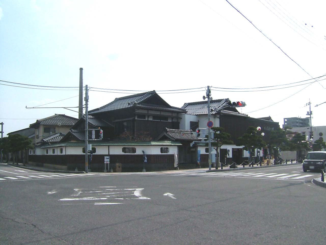 交差点の角に建つ、瓦屋根と白壁の千代むすび酒造の建物