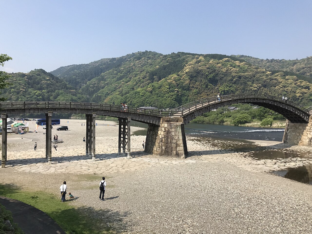 岩国市の錦川に架かる木造の錦帯橋。緑の山を背に、石積みの橋脚の上に弧を描く橋が連なる