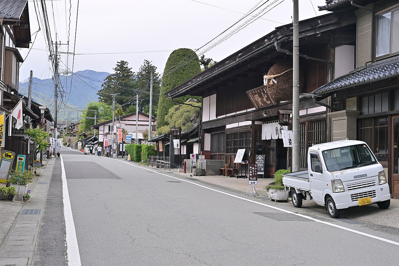 北杜市白州町の旧甲州街道・台ヶ原宿の通り。右手に杉玉を下げた山梨銘醸（七賢）の木造の建物が並び、奥に山並みが見える